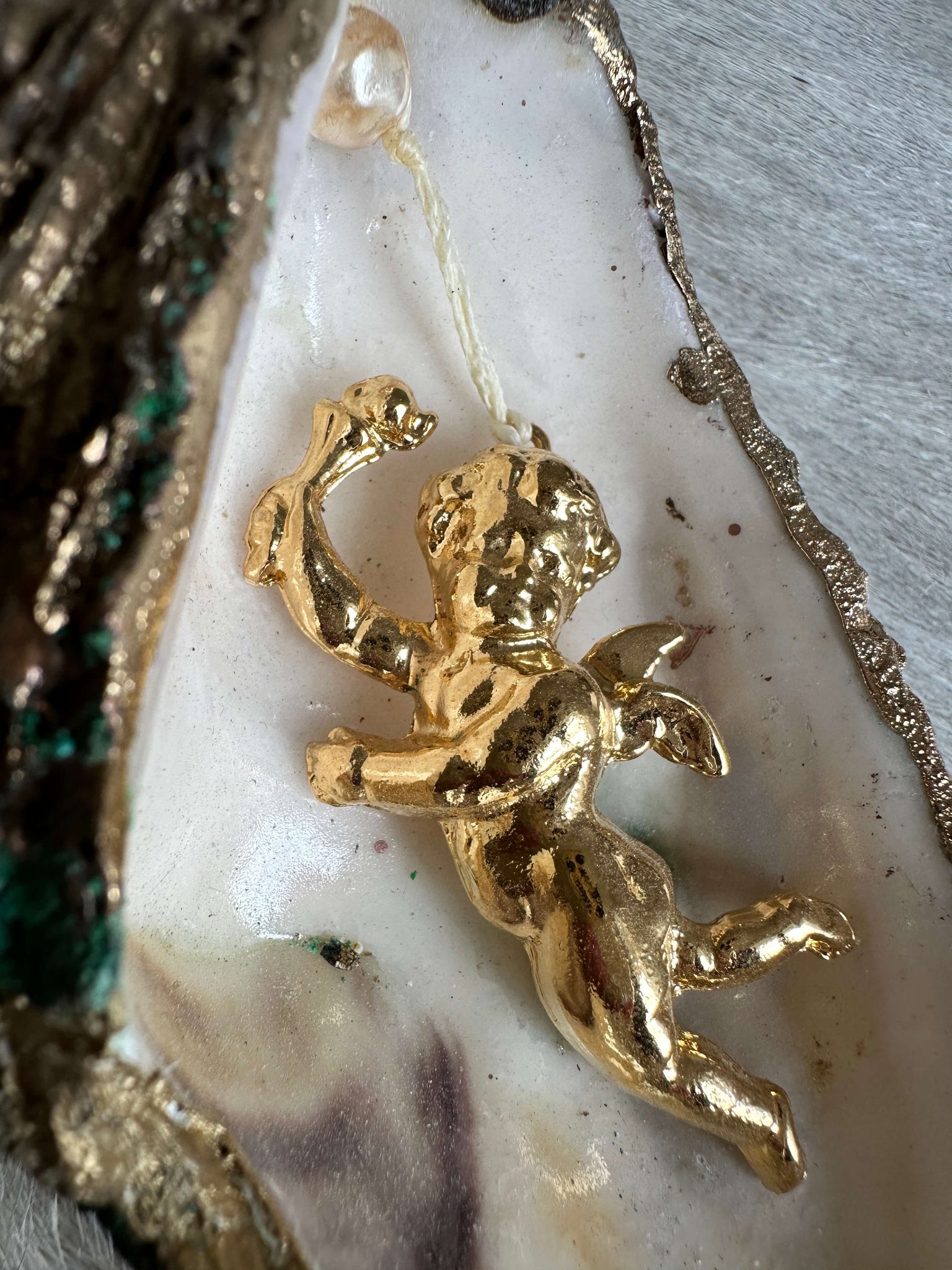 Oyster shell with pendant: shiny putti, right 