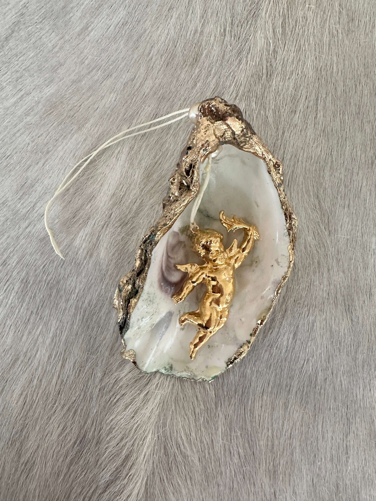 Oyster shell with pendant: shiny putti, left 